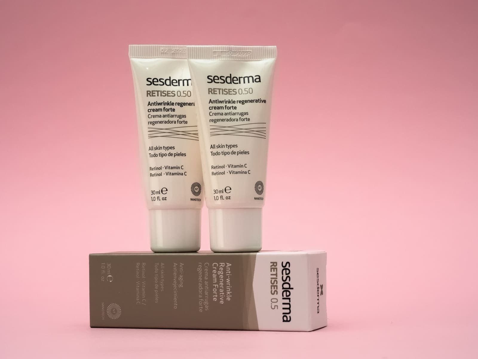 Anti-wrinkle cream jars on a pink background, used to support skin firmness.
